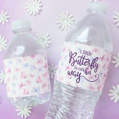 two plastic water bottles sitting next to each other on top of a purple tablecloth