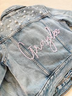 PERSONALIZED BABY, TODDLER & KID'S JEAN JACKET    These customizable jean jackets are perfect for the little princess in your life and make great gifts, too! The lettering is hand-embroidered and unique to each jacket. These are so unique and adorable, no two designs are the same! Want pearls added to yours? Drop that in the notes! Cold-wash delicate and hang-to-dry for longevity.    SHIPPING:    As this product is made to order, the current turnaround time is 1-3 weeks.   LOCAL PICKUP:    For l Cute Fitted Denim Jacket With Pockets, Customizable Denim Jacket For Spring, Customizable Spring Denim Jacket, Spring Customizable Denim Jacket, Customizable Long Sleeve Denim Jacket For Spring, Customizable Denim Outerwear For Spring, Cute Fitted Embroidered Outerwear, Pink Embroidered Cotton Denim Jacket, Customizable Trendy Denim Jacket For Spring