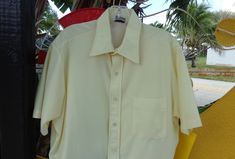 "1970's Men's Pale Yellow Shirt by Qiana 100% Dupont Nylon Short Sleeve One front pocket Shirt tail hem MEASUREMENTS IN INCHES: 50\" Chest 50\" Hem 20\" Back shoulder to shoulder 16\" Side Length underarm to hem 6\" Arm Length underarm to cuff 10\" Arm Length shoulder to cuff 16 1/2\" Neck 30 \" Back Neck to Tail INTERNATIONAL CUSTOMER?? Please email for Shipping Info" 1980s Men, Gogo Dress, Great Coat, Merino Sweater, Yellow Shirt, Yellow Shirts, Vintage Blazer, Star Dress, Pocket Shirt