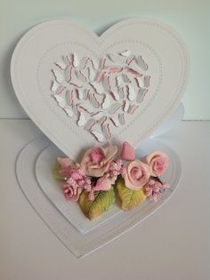 a white heart shaped card with pink flowers