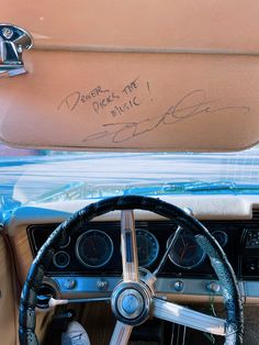 the interior of an old car with autographs and writing on the dash board