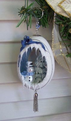 a christmas ornament hanging from the side of a tree with snow on it