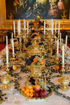 the table is set with candles, fruit and other decorations for an elegant dinner party