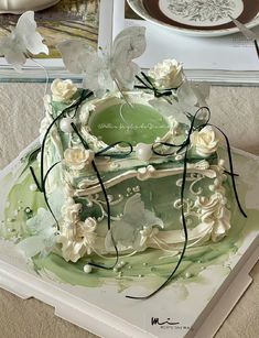 a green and white cake with flowers on it