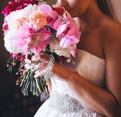 a woman in a wedding dress holding a bouquet of flowers