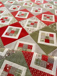 a quilted table runner with red, green and white squares on it's edges