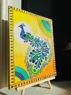 an easel with a painting of a peacock on it