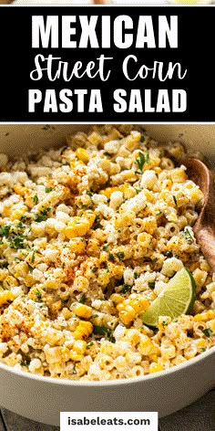 mexican street corn pasta in a white bowl with a wooden spoon and lime wedges on the side