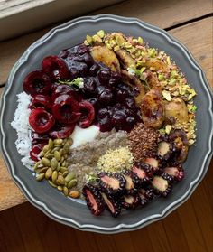 a plate filled with different types of food on top of a wooden table next to a window