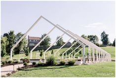 a white structure sitting on top of a lush green field