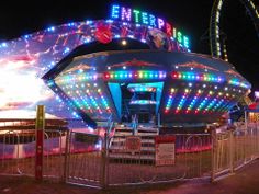 an amusement park at night with colorful lights