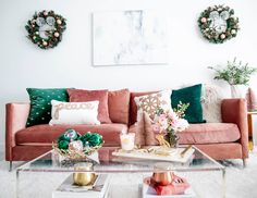 a living room with pink couches and christmas wreaths on the wall above them