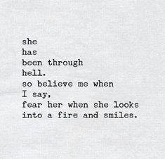 an old typewriter with the words she has been through hell so believe me when i say, fear her when she looks into a fire and smiles