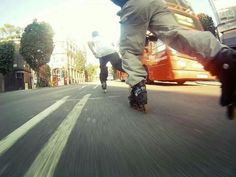 two people riding skateboards down the street