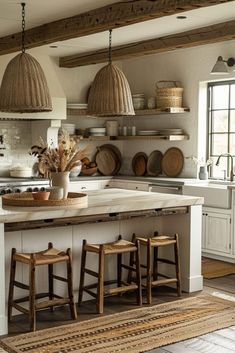 a kitchen with two stools in front of an island and several baskets on the wall