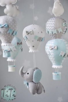 a baby mobile with several hot air balloons and an elephant hanging from it's side