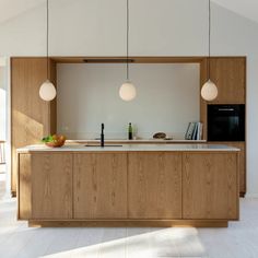 a kitchen with wooden cabinets and hanging lights