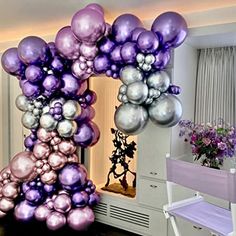 the balloon arch is decorated with purple and silver balloons