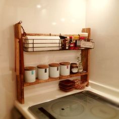 a kitchen with a stove top and shelves on the wall