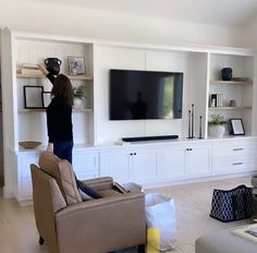 a woman standing in front of a flat screen tv