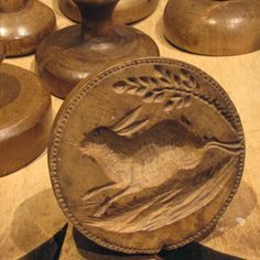 an old coin sitting on top of a wooden table next to other wood pieces and vases