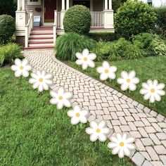 some white flowers are in front of a house