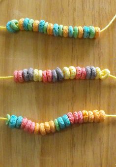 three colorful candy beads are on a wooden table with string attached to the bead