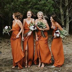 a group of women standing next to each other in front of some trees and bushes