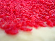 a red cake with white frosting is shown in close up view, it looks like something out of the past