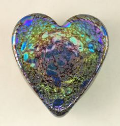 a heart shaped glass object sitting on top of a table