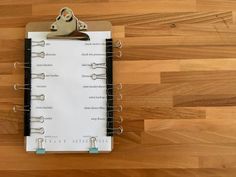 a clipboard attached to a wooden floor with some paper clips on top of it