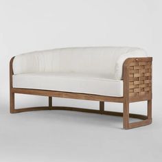 a wooden bench with white upholstered cushions