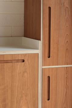 a wooden cabinet with two drawers next to a brick wall