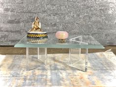 a glass coffee table with a buddha statue on top