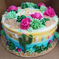 a birthday cake decorated with flowers and cacti