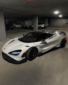 a white sports car parked in a parking garage