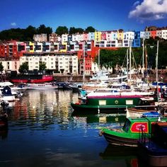 many boats are docked in the water near some buildings