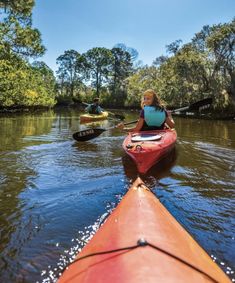 two people in kayaks paddling down the river