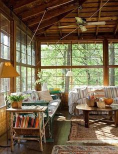 a living room filled with lots of furniture next to a window covered in wood planks