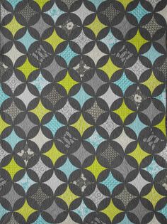 a black and yellow quilt with circles on the front, in blue, green, gray and white