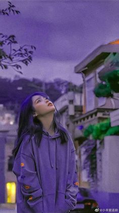 a woman standing in front of a building with her eyes closed and looking up at the sky