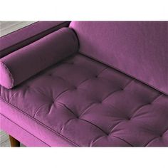 a purple couch sitting on top of a wooden floor