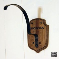 a wooden hook with the word honda on it and a black handle attached to it