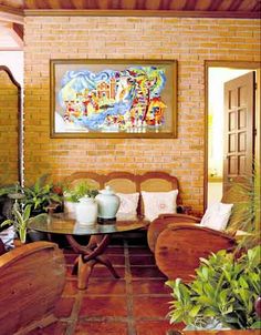 a living room filled with lots of furniture next to a painting on a brick wall