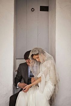 the bride and groom are sitting together on the steps in front of an open door