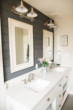 a bathroom with two sinks and mirrors on the wall