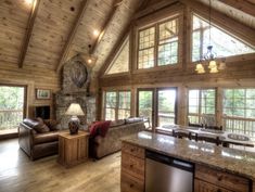 a living room filled with furniture and a fire place in the middle of a kitchen