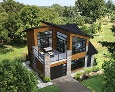 an aerial view of a modern home in the middle of some trees and grass area