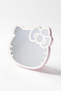 a white hello kitty shaped mirror sitting on top of a table