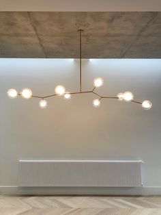 a light fixture hanging from the ceiling over a radiator in an empty room